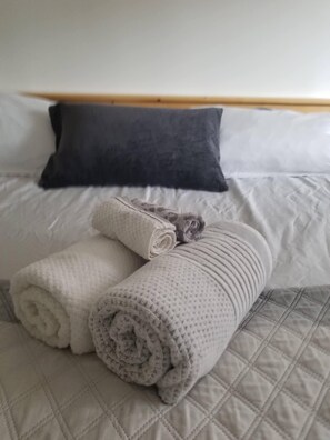 Restful retreat with a neatly made bed and plush towels at the ready.