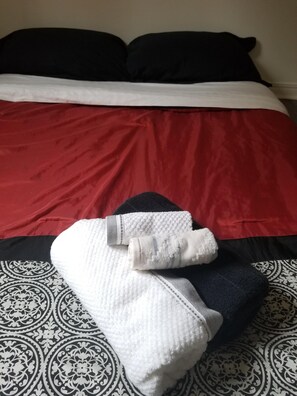 Restful retreat with a neatly made bed featuring a patterned bedspread and two pillows.