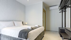 Een moderne hotelkamer met een groot bed, een bureau en een kledingkast.