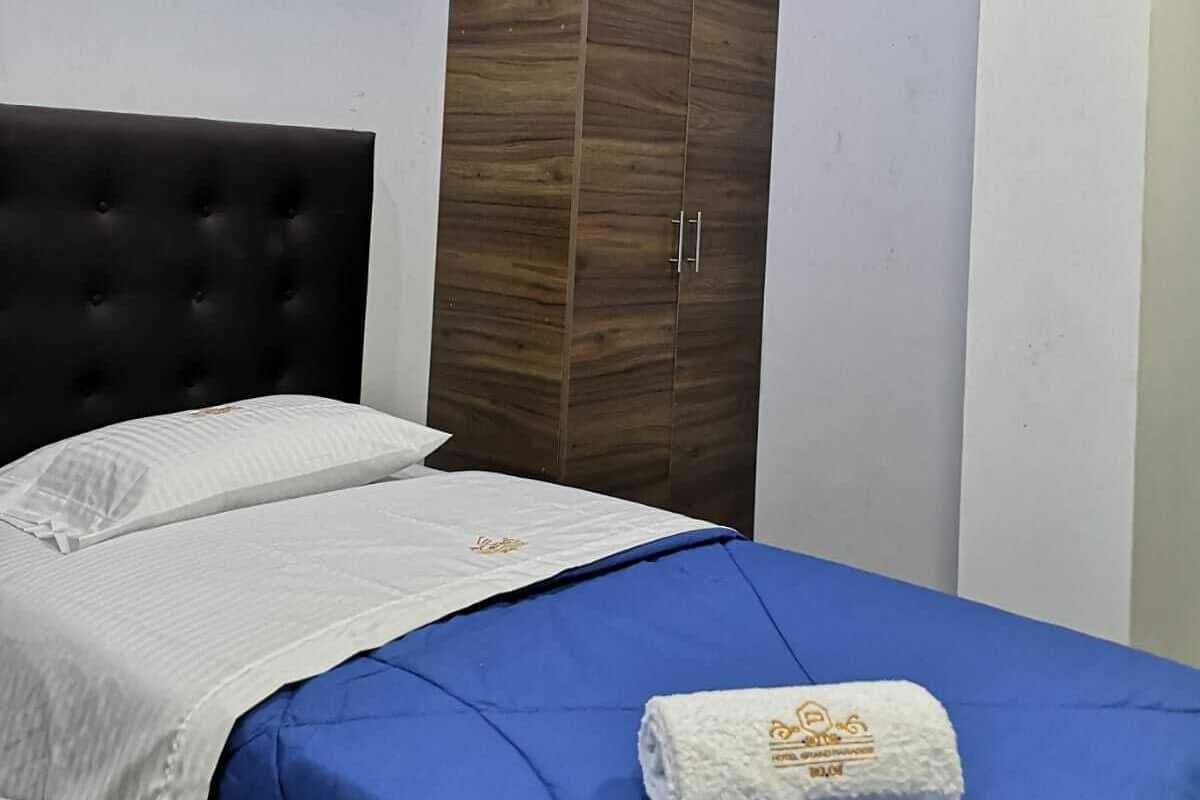 Ein Schlafzimmer mit Bett, Kleiderschrank und Deckenleuchte.