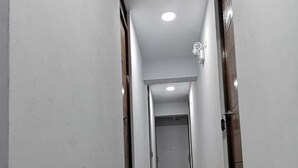 A hallway with a shiny tiled floor, white walls, and a door at the end. - Hotel Grand Paradise Marcona (Marcona)