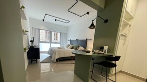 A modern bedroom with a bed, bedside table, and a small desk area with a chair. - Modern & Cozy Studio in San Telmo Num7006 (Buenos Aires)