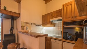 A kitchen with wooden cabinets, a dishwasher, and a stove. - Appartement Denali - Welkeys (Demi-Quartier)