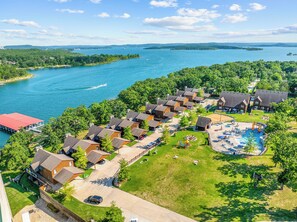 Un complexe hôtelier comprenant plusieurs chalets de style bungalow, un espace piscine central et une vue sur le lac.