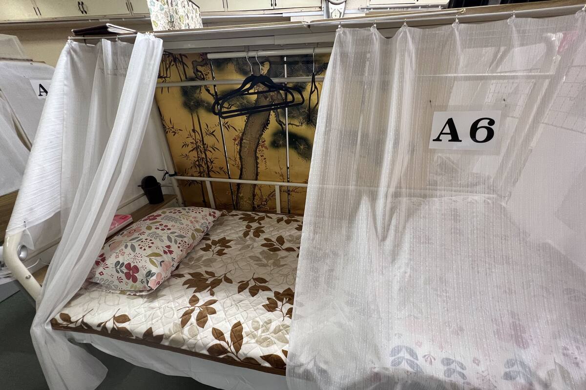 A single bed with a floral-patterned mattress, a white canopy, and a wall-mounted number sign 'A6'.