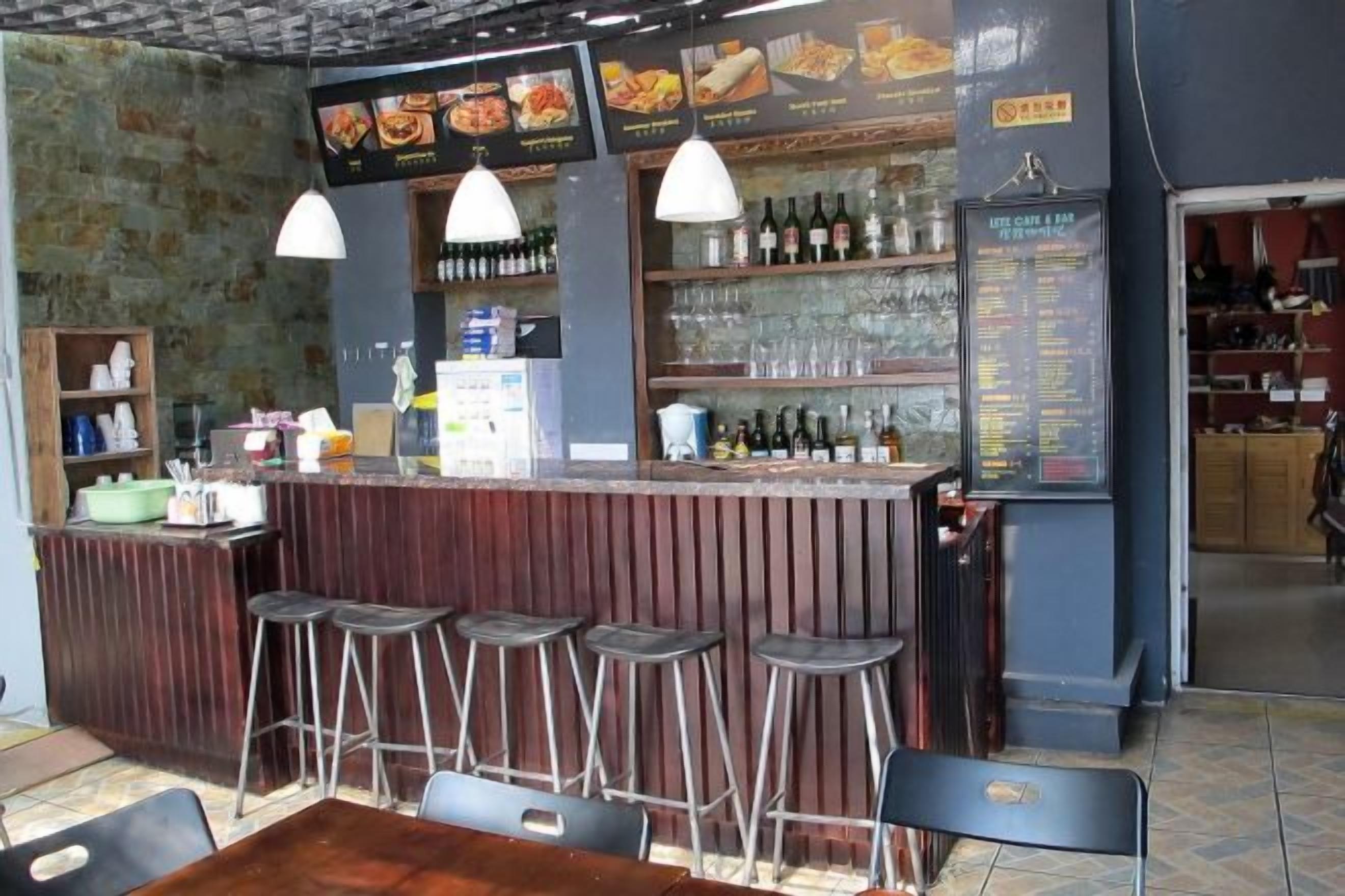 A bar area with stools, a counter, and a menu board.