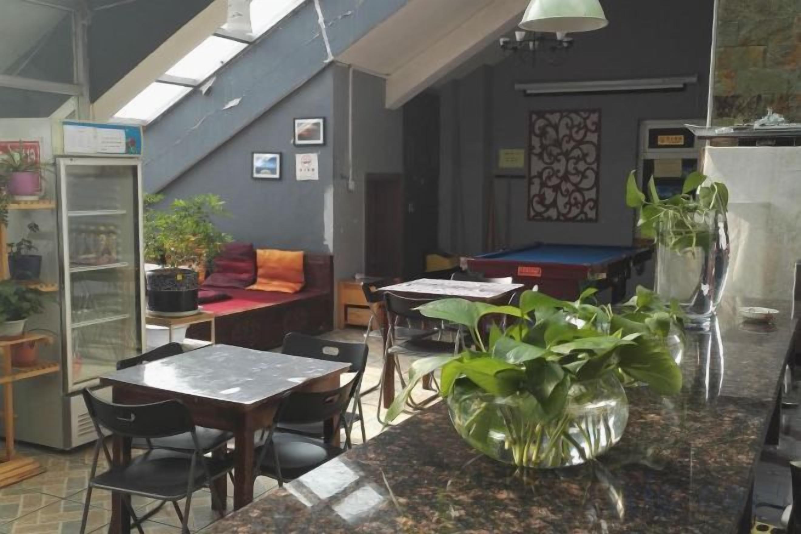 A cozy indoor space with a dining area, a sofa, and a pool table.