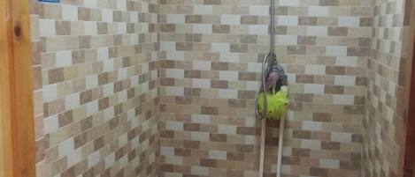 A shower area with tiled walls and a showerhead.