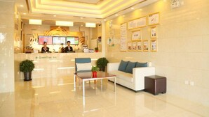 A hotel lobby with a reception desk, a white sofa, a coffee table, and a potted plant. - Greentree Inn Beijing Fengtai District Changxindian Express Hotel (Beijing)