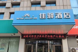 Un letrero de hotel con el nombre 'INZONE ALLIKE INN' y caracteres chinos.