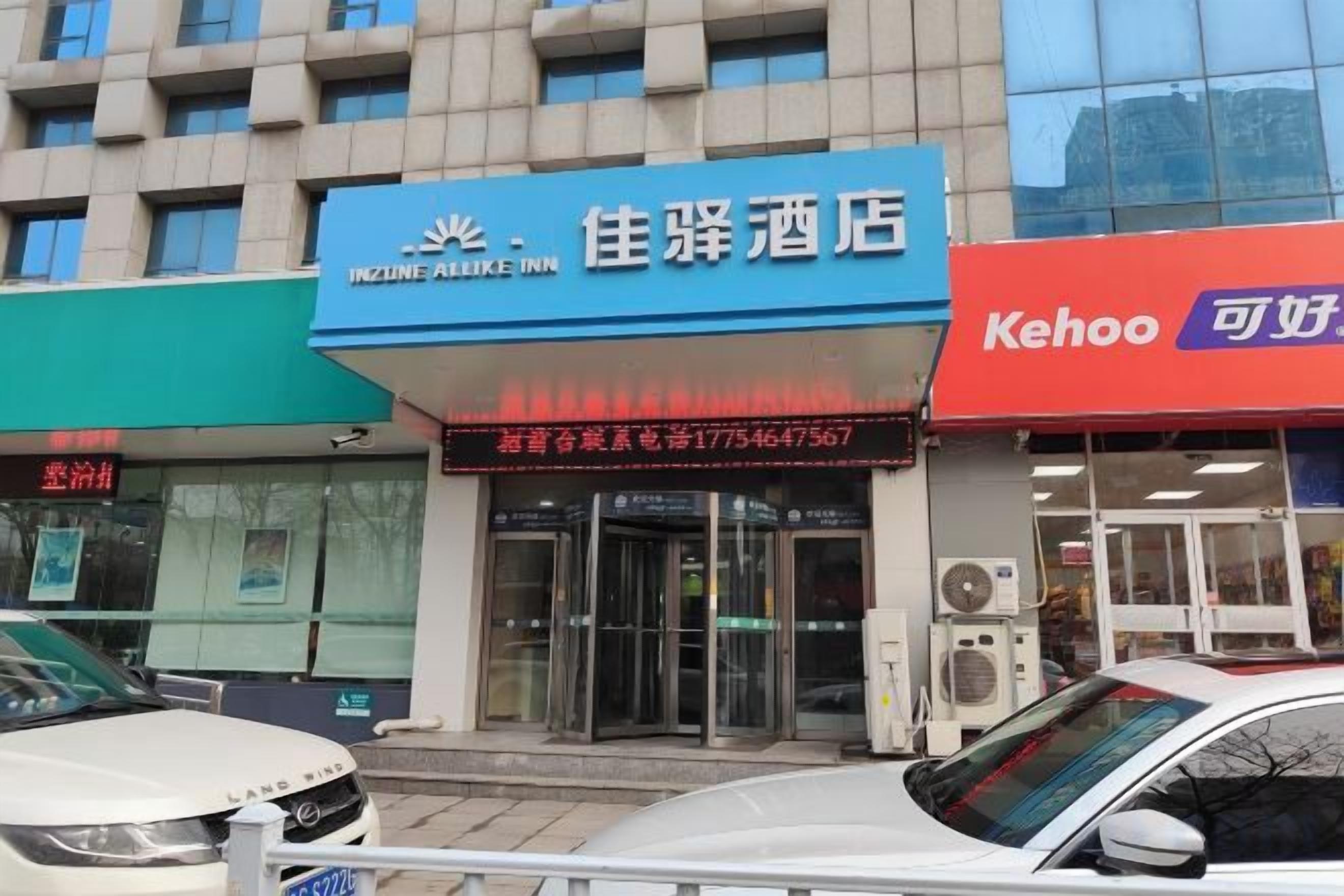A hotel with a blue sign, a red sign, and a glass facade.
