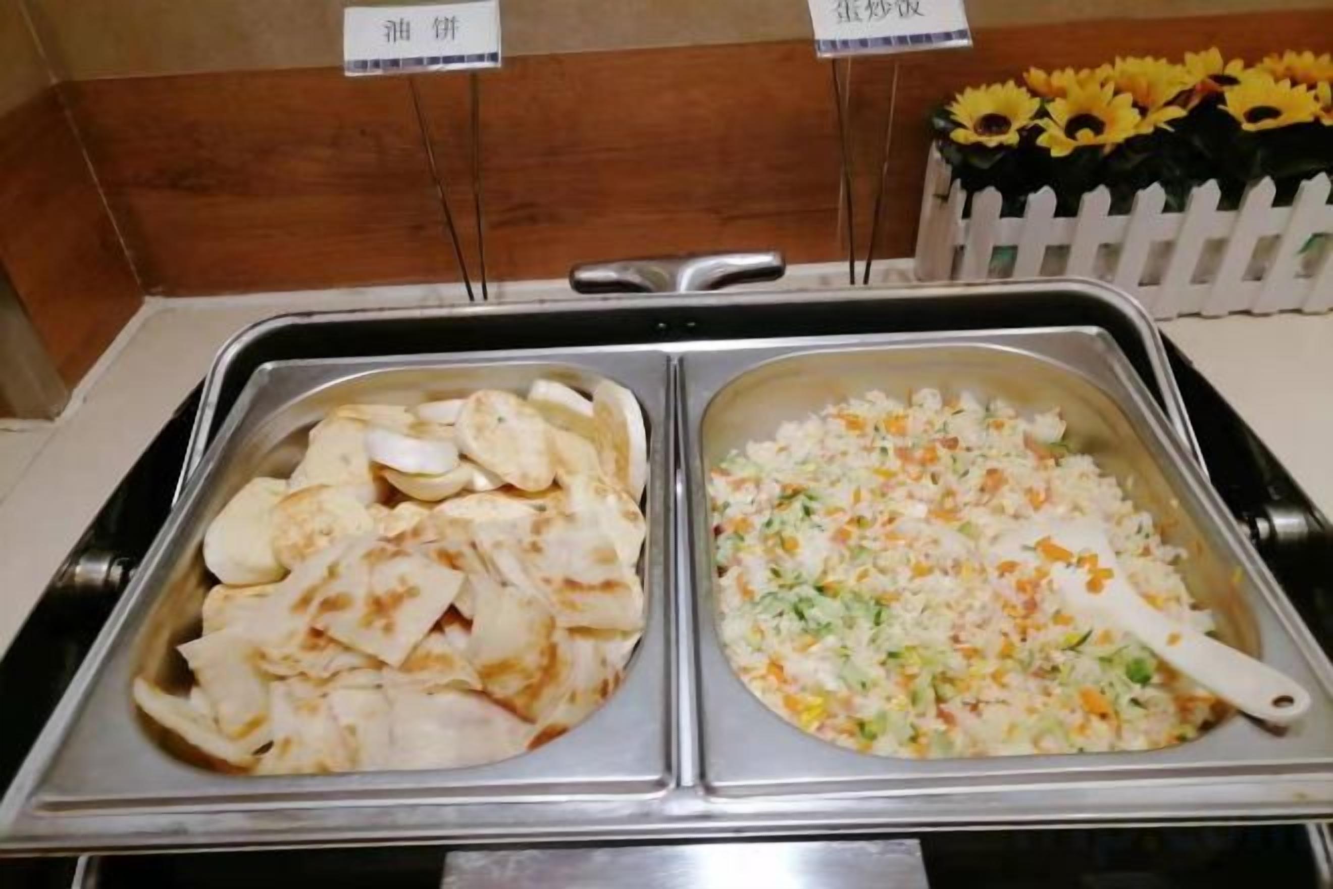 Un buffet con due vassoi: uno con dei ravioli e l'altro con un'insalata.