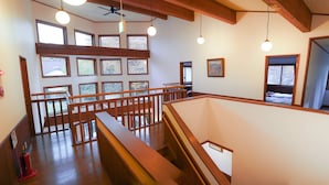 A spacious interior with a wooden balcony, multiple windows, and a ceiling fan. - Villa Shizen Hakuba (Hakuba)
