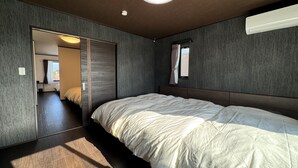 Een moderne slaapkamer met een groot bed, een kledingkast en een plafondlamp.