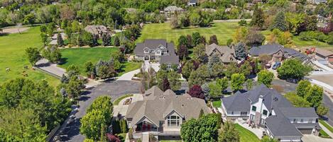 A residential area with houses, green lawns, and a clear sky.
