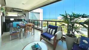 A modern living room with a balcony overlooking a clear blue sky and a distant view of the ocean. - Wai Wai Cumbuco Resort (Caucaia)