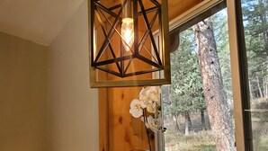 A kitchen with a wooden countertop, a hanging geometric light fixture, a potted orchid, and a window with a view of trees. - Altitude Adjustment awaits! Large and spacious, perfect for a family getaway  (Star Valley Ranch)