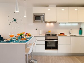 Enjoy cooking in this well-equipped kitchen with oven, microwave, and dining area for two.