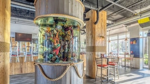 A restaurant with a large aquarium centerpiece, wooden accents, and modern furniture.