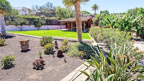 A well-maintained garden with a variety of plants, a palm tree, and a small wooden structure. - Villa Parralito Ingenio by Interhome (Maspalomas)