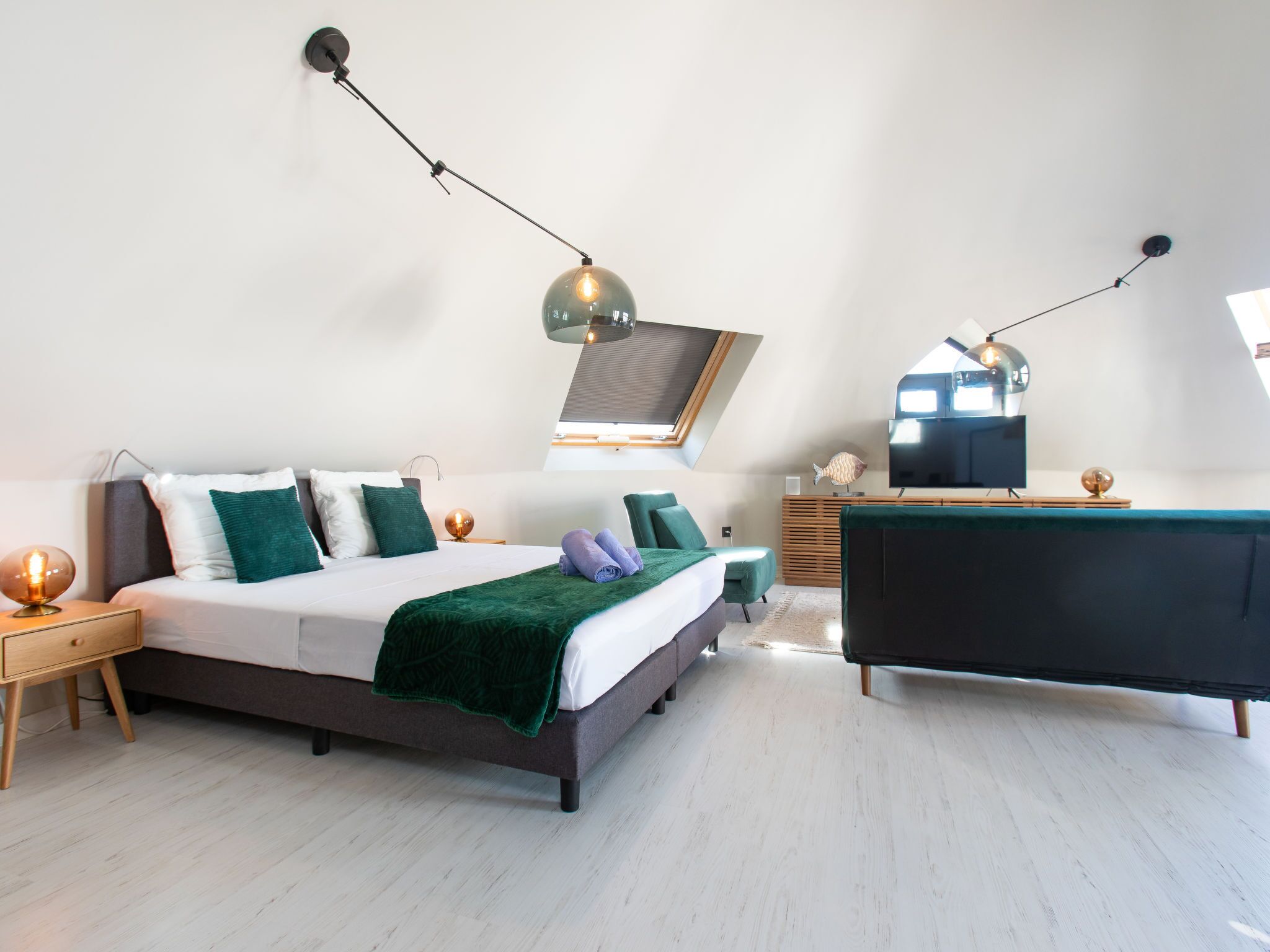 Una camera da letto moderna con un letto grande, una scrivania e una televisione.