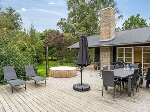 Une terrasse dotée de mobilier d’extérieur, d’un jacuzzi et d’un espace barbecue.