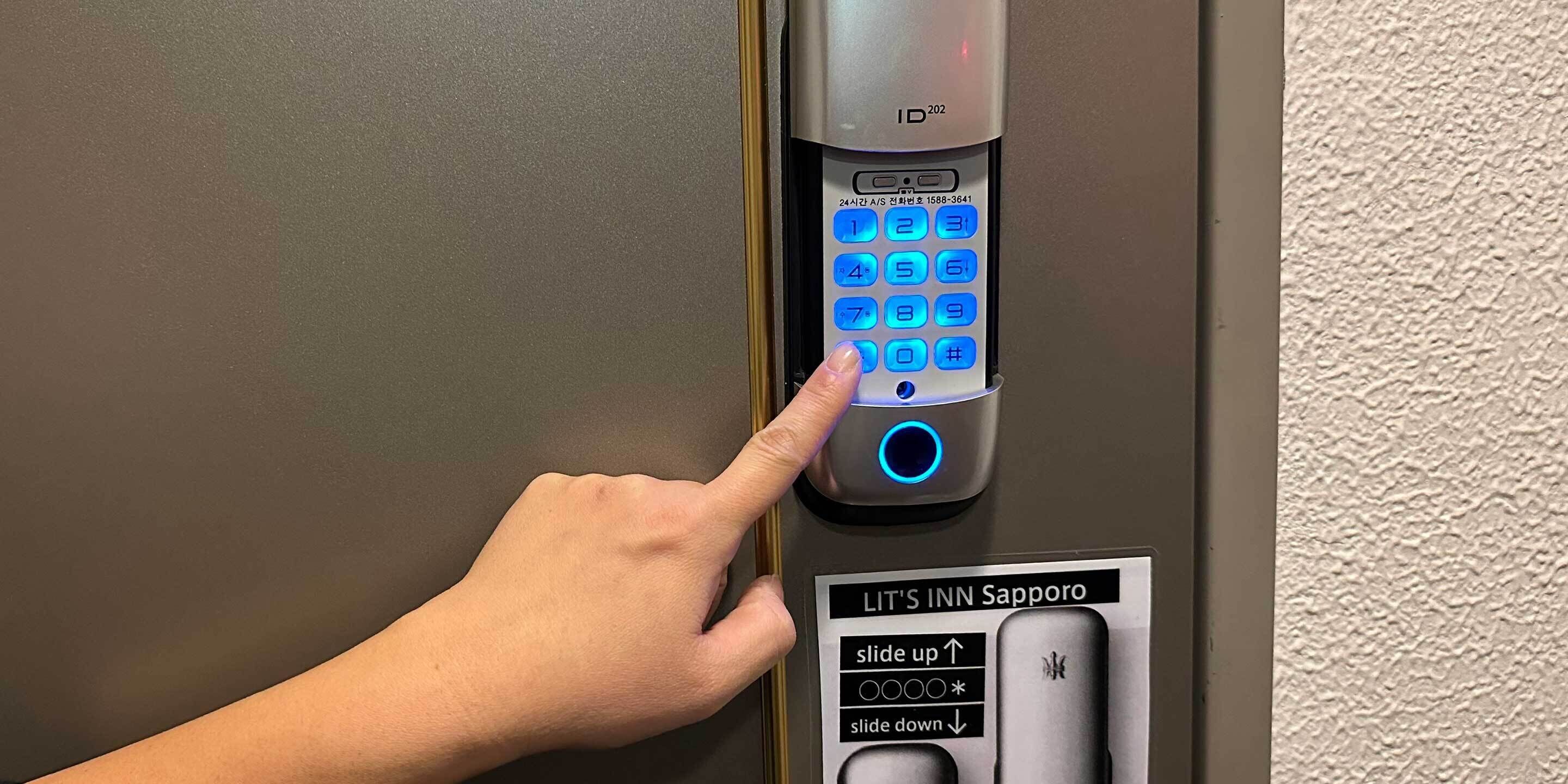 A hand pressing a button on a digital keypad lock.