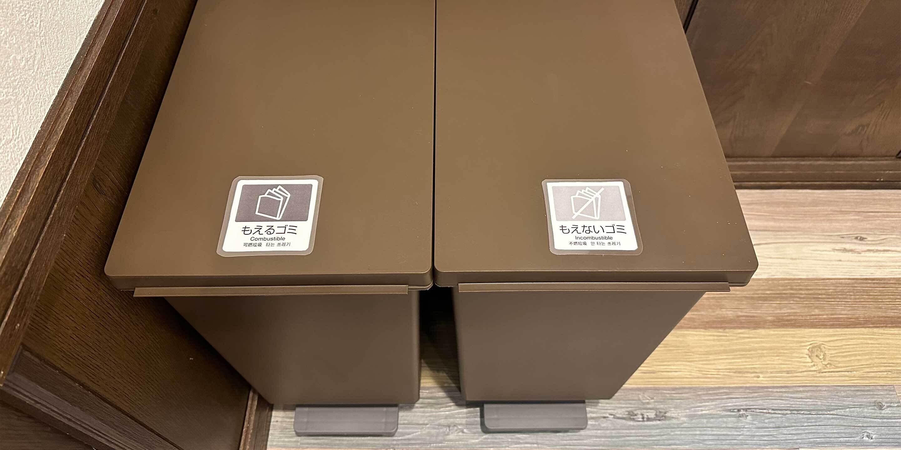 Two brown trash bins with labels indicating they are for combustible and non-combustible waste.