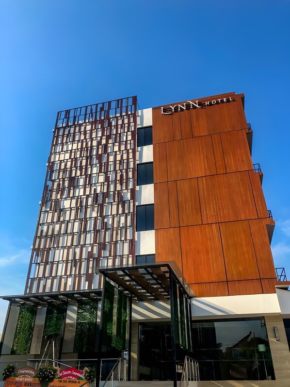 Un hotel moderno con fachada de madera vertical y un diseño de ventanas en forma de cuadrícula.