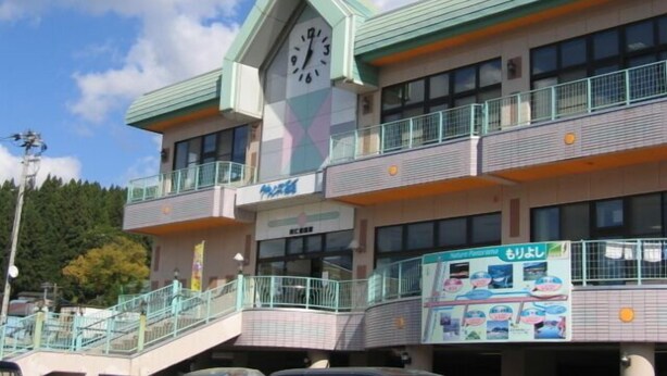 Ein Gebäude mit einer Uhr, mehreren Balkonen und einem Schild mit der Aufschrift 'Motel'.