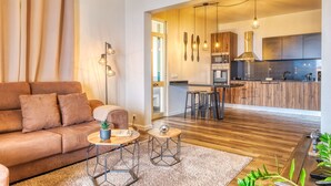 Un salon moderne avec un canapé, une table basse et une vue sur la cuisine.