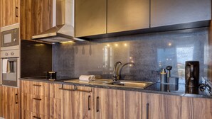 Une cuisine moderne avec des meubles en bois, un évier en acier inoxydable et un four encastré.