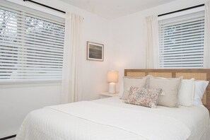 A bedroom with a bed, a nightstand, a lamp, and a picture on the wall. - Relaxing Countryside Stay w/ Game Room (St Thomas)
