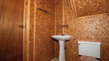 Un bagno con una porta in legno, un lavandino bianco e un water.