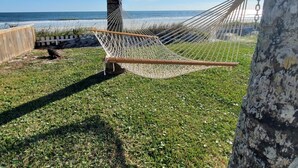 A hammock tied between two trees on a grassy area with a view of the ocean. - Coastal Bliss, Oceanfront Home minutes from downtown St Augustine! (St. Augustine)