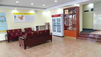 A lobby with a reception desk, a refrigerator, a display cabinet, and a sofa.