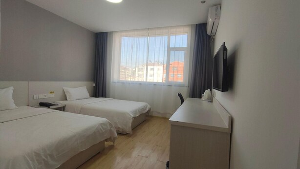 A hotel room with two beds, a desk, a flat-screen TV, and a window with curtains. - 7 Days Inn Changzhi Qin County (Changzhi)