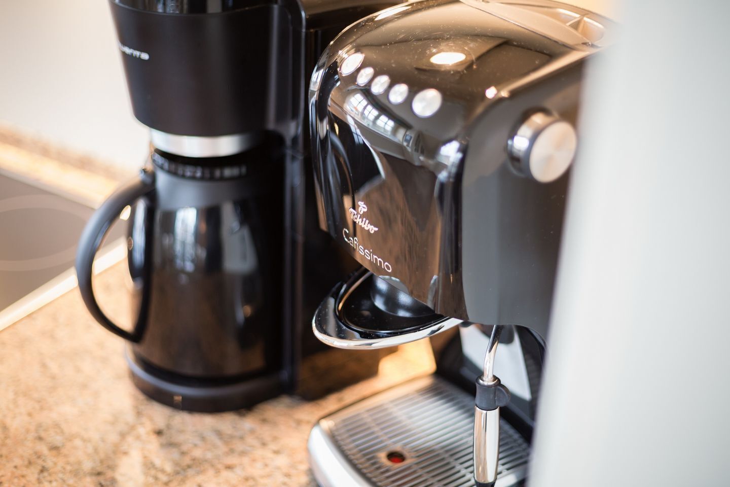 A coffee machine with a drip tray and a coffee maker on a countertop.