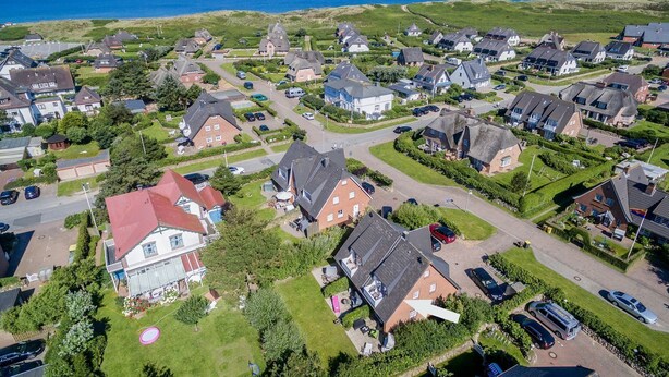 An aerial view of a coastal residential area with houses, roads, and a clear view of the sea. - Friesenhörn, App. 4 Links - Dorfteich. Dünen. Viel Erholung (Wenningstedt-Braderup (Sylt))