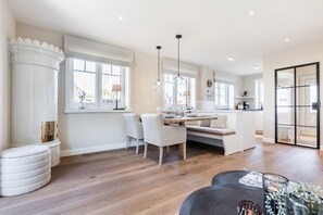 Una cucina moderna con zona pranzo, ampie finestre e una panca integrata.