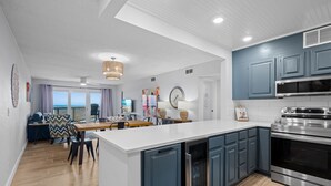 A modern kitchen with blue cabinets, a stainless steel range, and a large island.