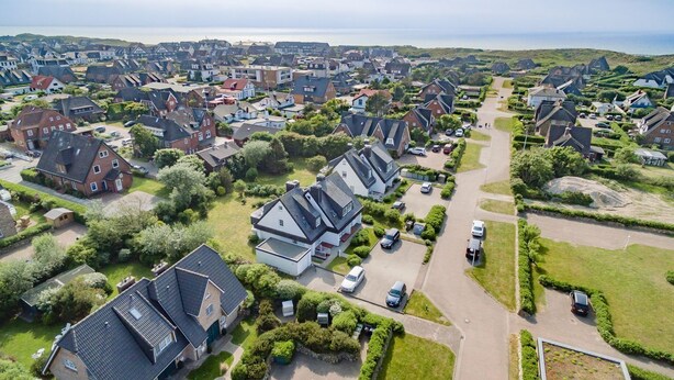 Eine Vogelperspektive eines Wohngebiets mit Häusern, Straßen und Grünflächen.