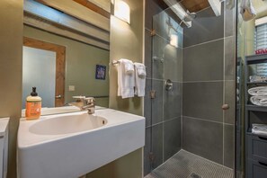 Une salle de bain avec un lavabo, un miroir et une douche.