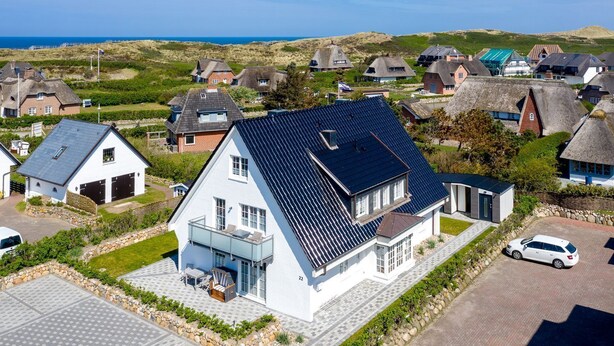 Una casa moderna con techo inclinado, un balcón y un garaje.