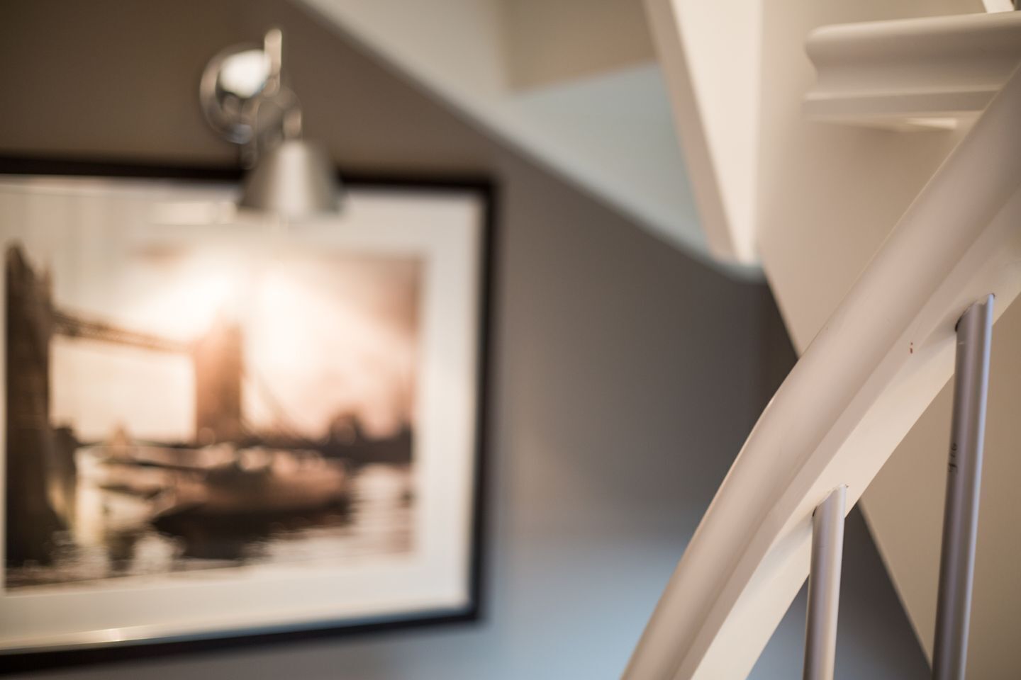 A staircase with a handrail and a framed picture on the wall.