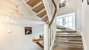 A spiral staircase with wooden steps and white walls.