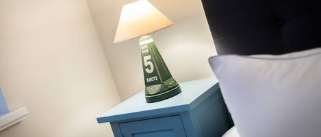 A bedside table with a lamp and a pillow.