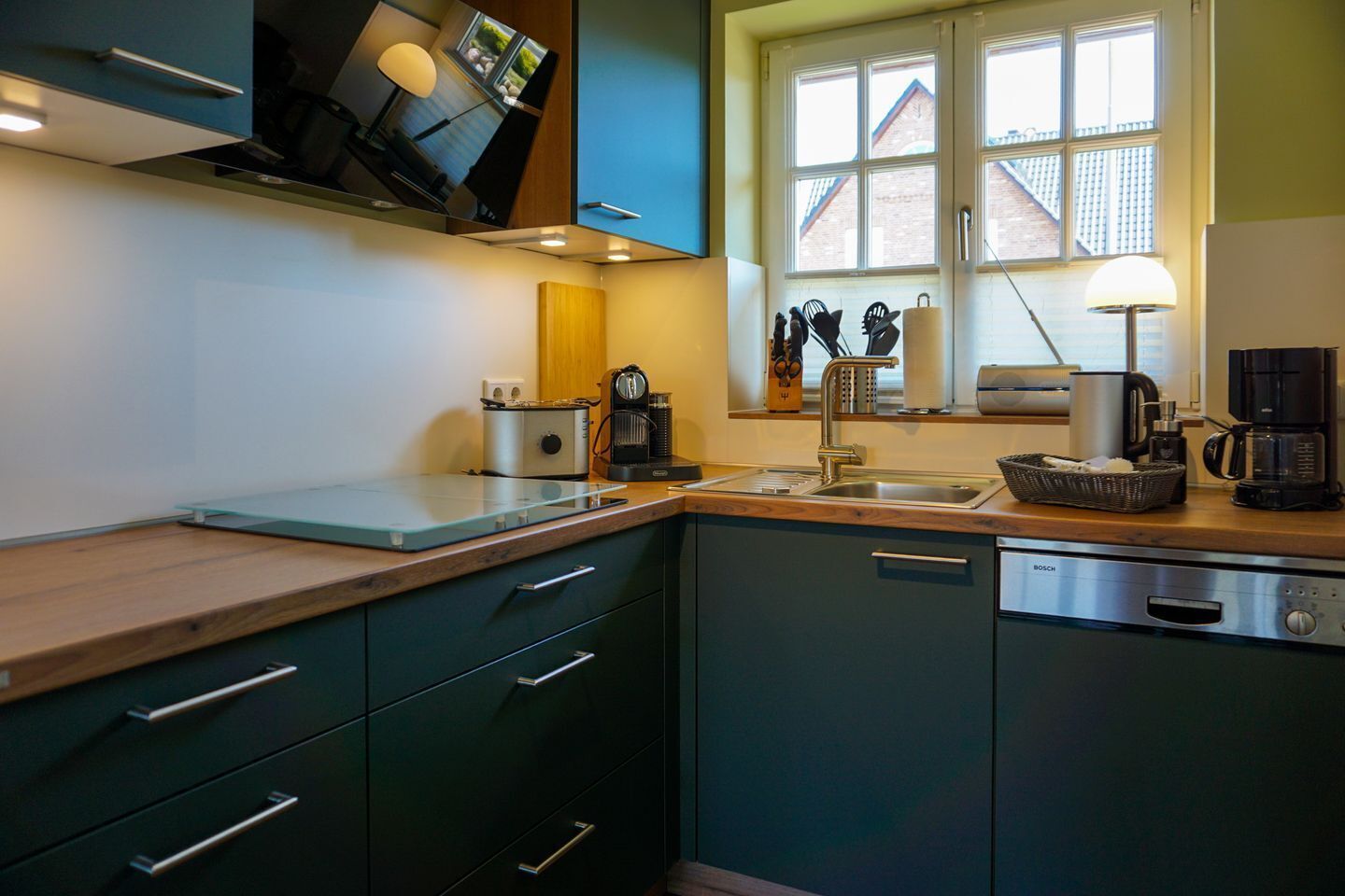 A modern kitchen with a built-in oven, a coffee maker, and a sink.