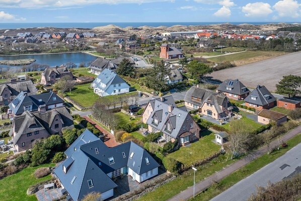 Una zona residencial con casas, un lago y una carretera.