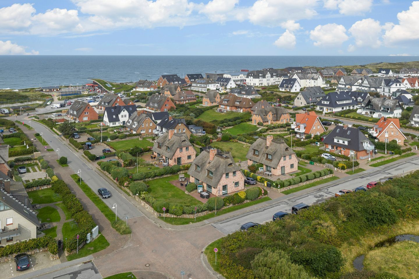 Zona residencial costera con casas, calles y vista al mar.